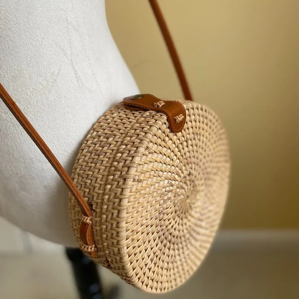 Round solid rattan woven crossbody purse cloth lined, leather accents.